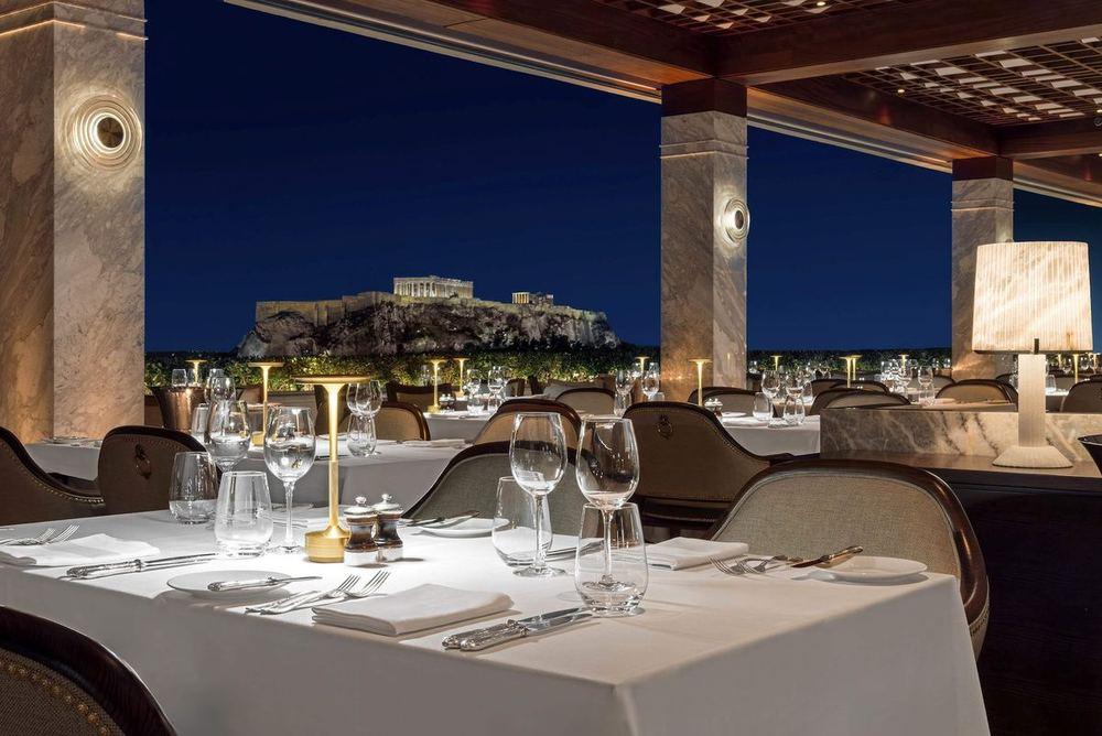 The GB Roof Garden at night: white tablecloths and the floodlit Parthenon behind