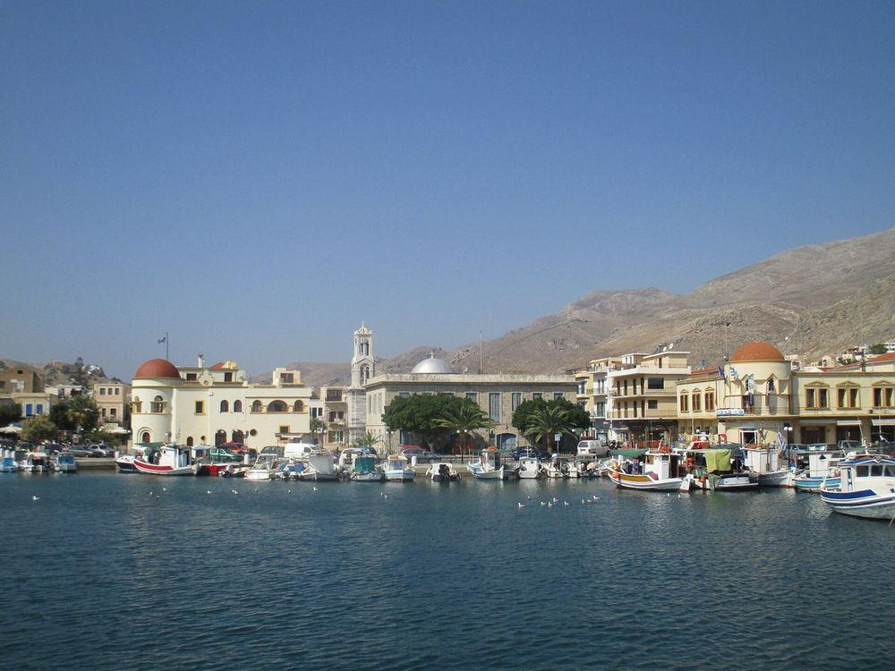 Pothia harbor on Kalymnos: small fishing boats moored along the quay below neoclassical houses