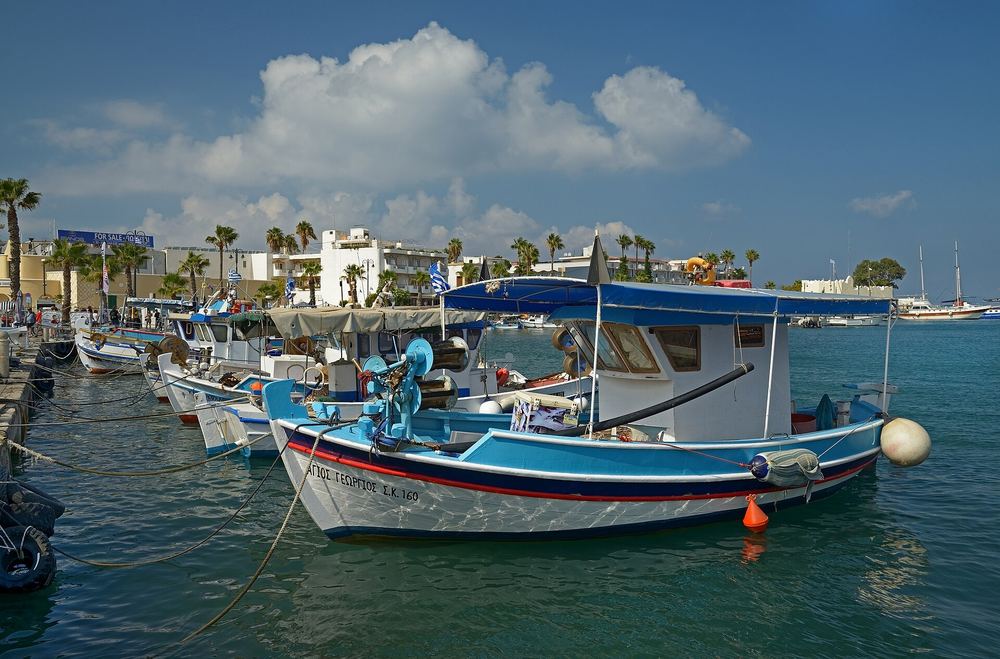 A blue-and-white wooden caique moored in Kos harbor