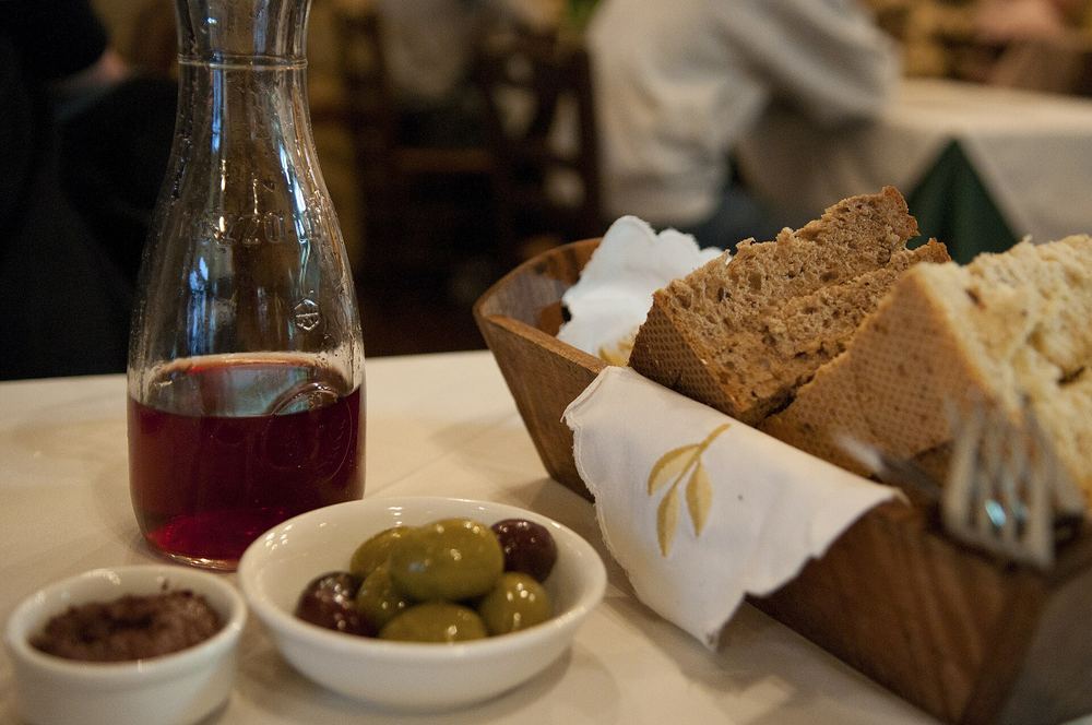 A taverna table in Kos: a carafe of red wine, olives and a basket of bread