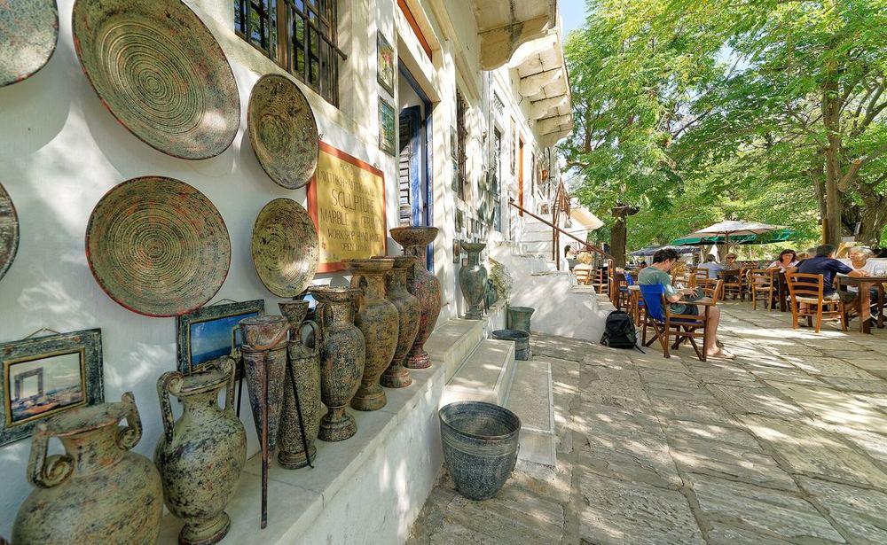 A marble-paved lane in Apeiranthos with a ceramics workshop's wares on the wall