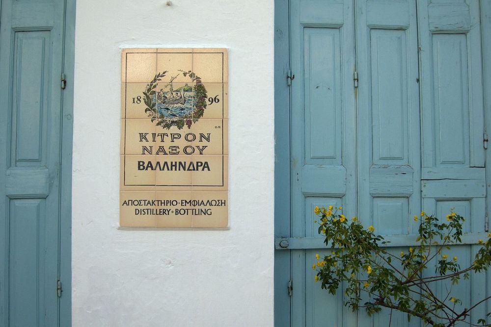 The Vallindras distillery's 1896 tiled sign between blue shutters in Halki