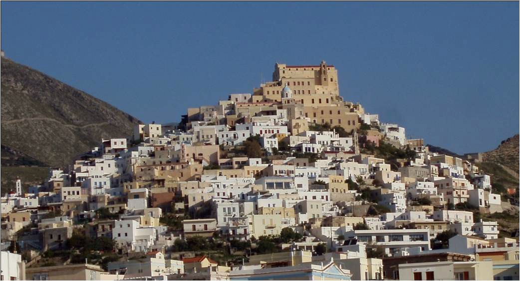 Ano Syros: white cubic houses stacked up a bare hillside to the walled Catholic church of St George on the summit